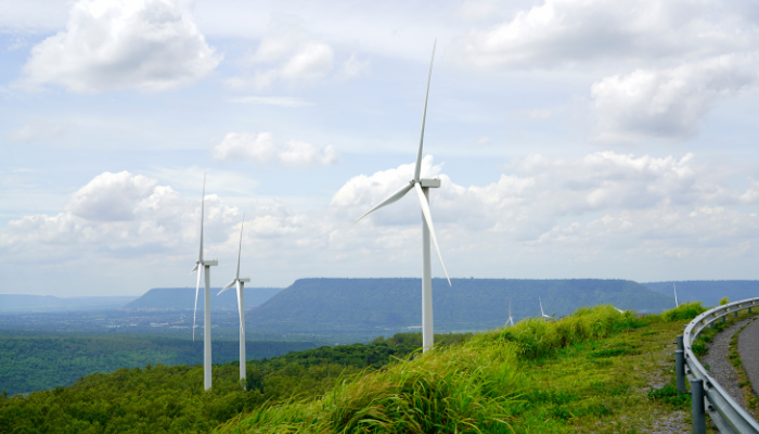 Aerogeneradores instalados sobre una colina verde, representando el impulso de energías limpias como respuesta a los Cambios Climáticos en Argentina.