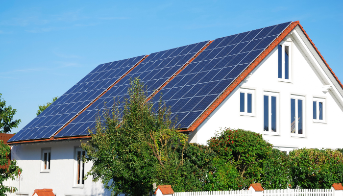 A house with a roof covered in solar panels, illustrating the shift toward clean energy solutions.