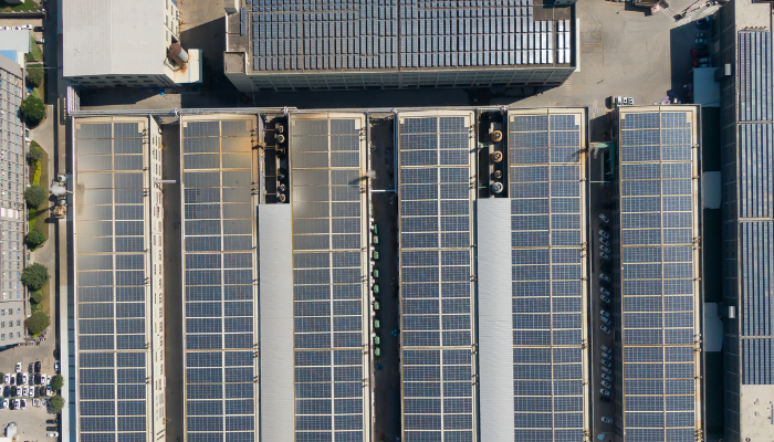 Vista aérea de un complejo industrial con paneles solares en los techos, destacando la implementación de Proyectos Energéticos en Argentina enfocados en energías renovables.