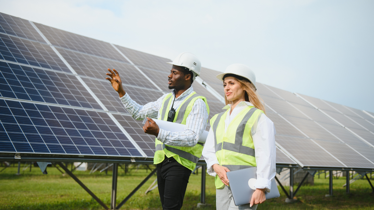 Dos técnicos con cascos y chalecos analizan el campo de paneles solares. La frase "Paneles solares" enfatiza el rol de la planificación y la evaluación técnica en energías renovables.