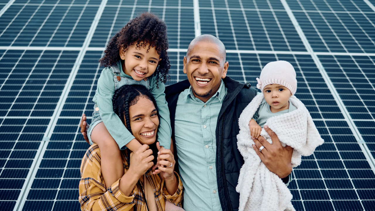 Una familia sonriente posa frente a un amplio campo de paneles solares. La imagen transmite un mensaje de bienestar, energía limpia y futuro sostenible para las próximas generaciones en el contexto argentino.