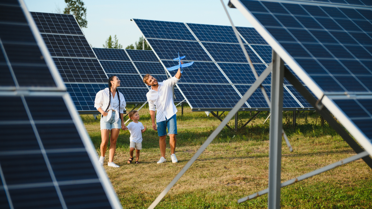 Una familia recorre un campo solar mientras el padre lanza un avión de juguete. La escena muestra cómo las nuevas generaciones se integran a la sostenibilidad, reforzando el valor cotidiano de los paneles solares portátiles.