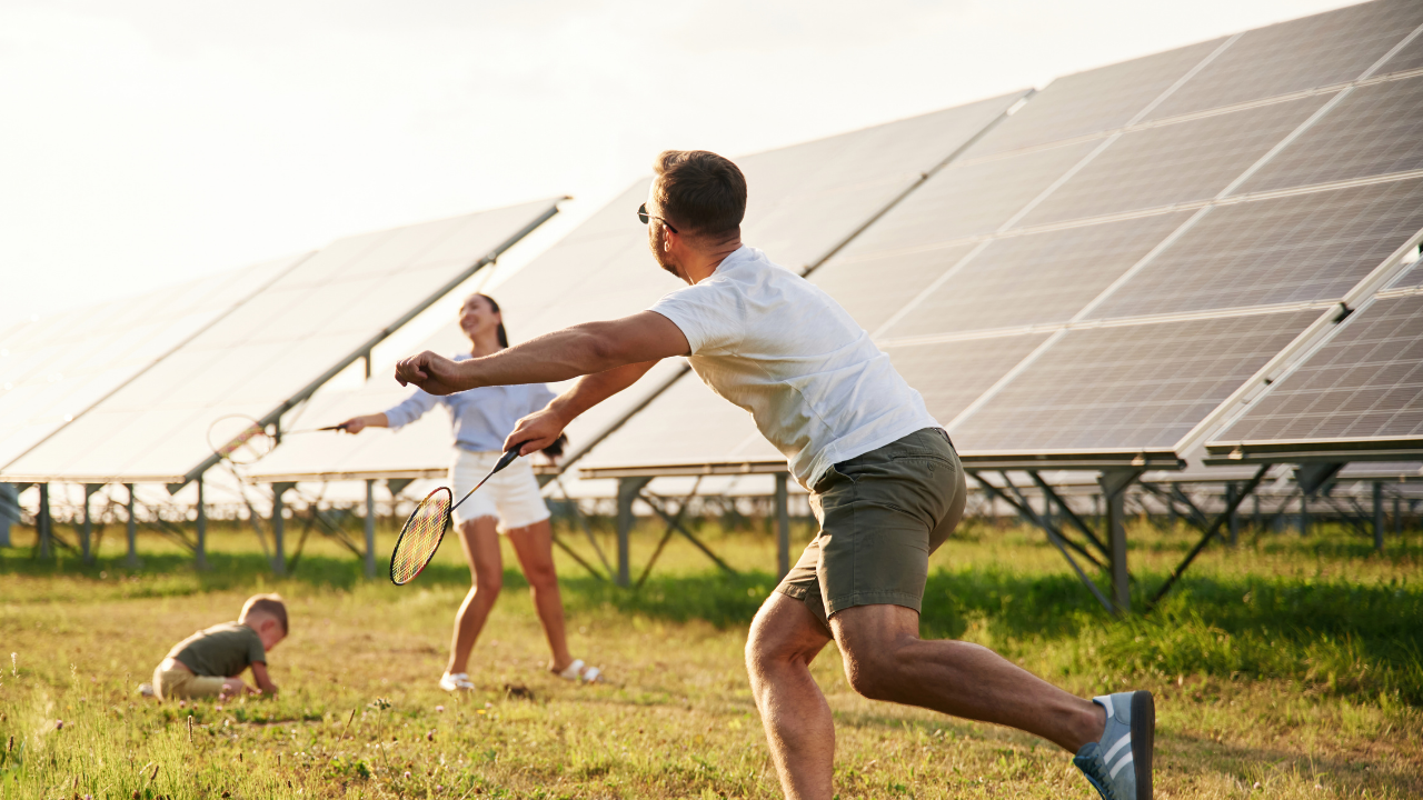 Una familia disfruta jugando al aire libre frente a una instalación solar. La escena transmite cómo la integración arquitectónica permite que las energías renovables se incorporen sin fricción a los espacios comunitarios y cotidianos.