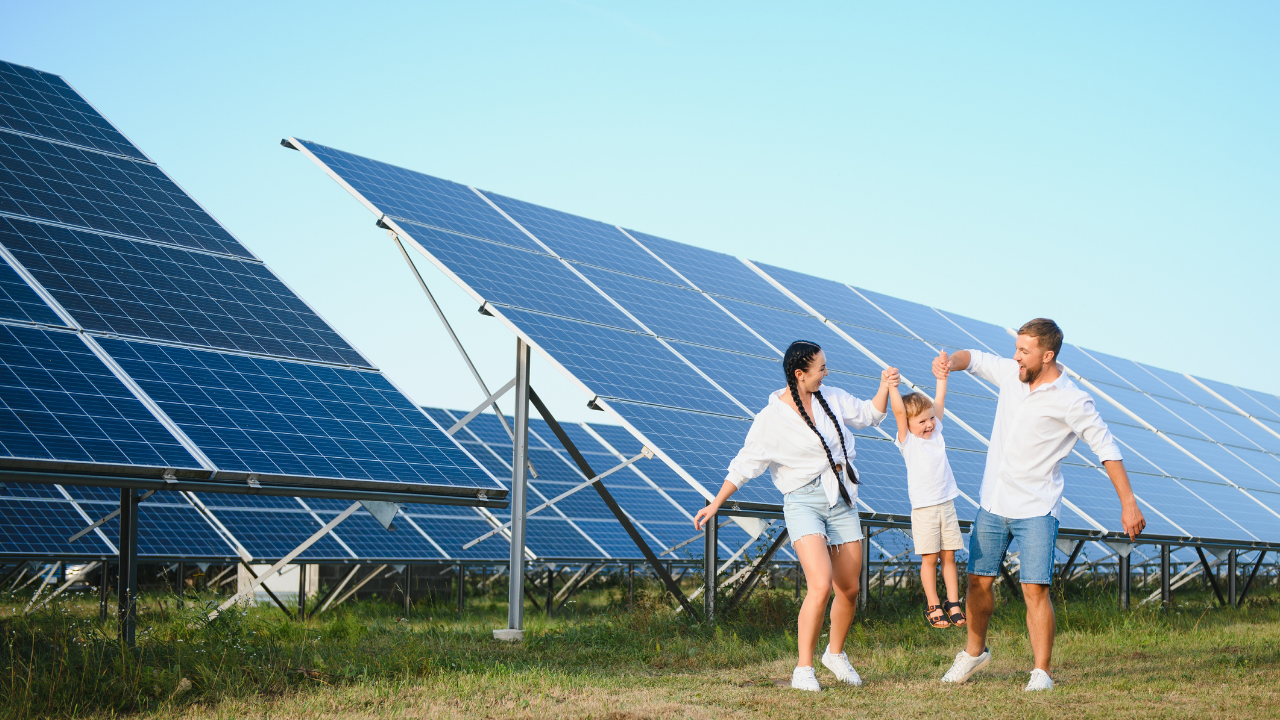 Una familia juega alegremente entre filas de paneles solares, representando una conexión directa entre energía limpia y calidad de vida en Argentina.