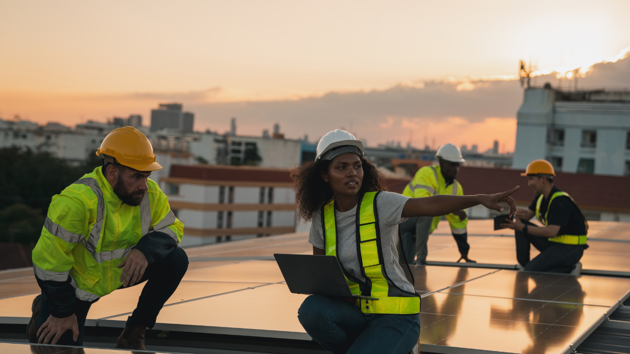 Un equipo instala paneles solares en una azotea urbana al atardecer, representando un compromiso concreto para reducir la huella de carbono en contextos metropolitanos argentinos.