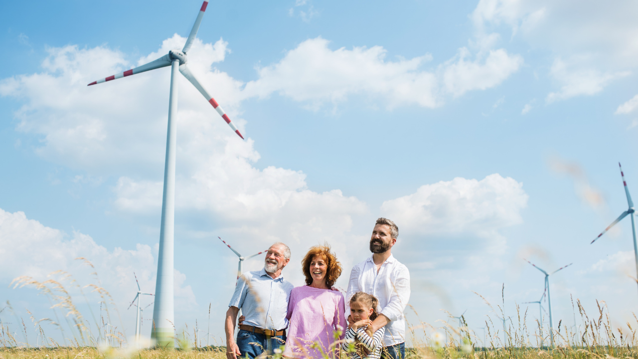 A smiling family stands among turbines, reflecting the broader community impact and trust in well-maintained wind infrastructure.