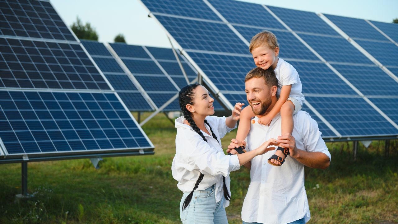 Una familia sonríe mientras el padre carga a su hijo sobre los hombros frente a paneles solares, reflejando el vínculo emocional y la esperanza asociada a la energía solar hogar en el ámbito familiar argentino.