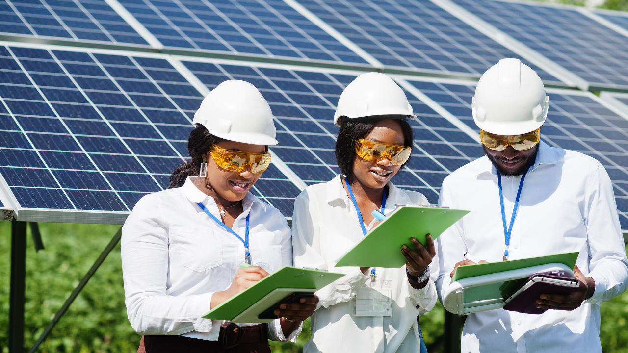 Three professionals inspect bifacial solar panels while taking notes on clipboards, illustrating the integration of solar energy in technical team work and field assessments.