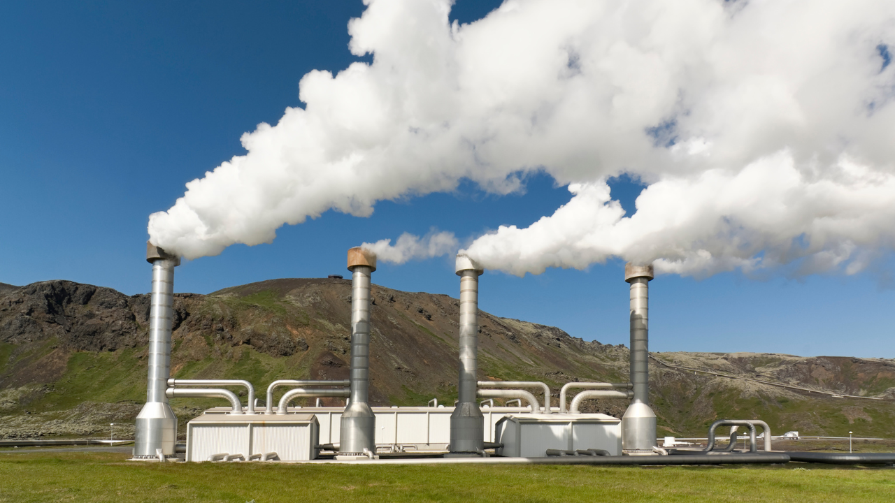 This geothermal plant, surrounded by green hills, emits clean steam, symbolizing the potential of Geothermal energy at home in eco-conscious British landscapes.