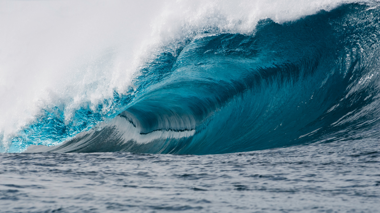Una ola perfectamente formada se eleva en el mar abierto, una muestra impresionante de la fuerza que impulsa la energía undimotriz.