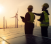 Two engineers in safety gear inspect solar panels and wind turbines at sunset, highlighting the role of aerothermal energy in Britain's green transition.