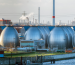 Una planta industrial moderna junto al agua sugiere la implementación tecnológica necesaria para convertir la energía undimotriz en electricidad sostenible.
