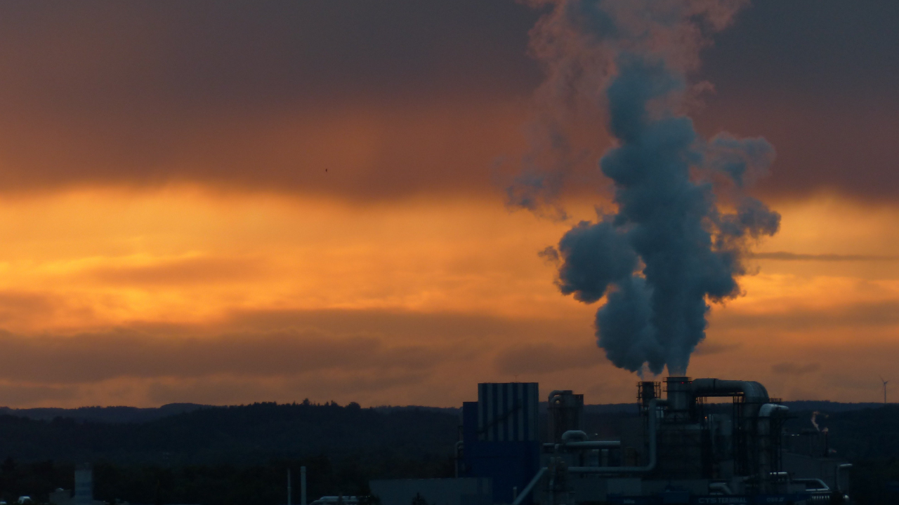 El vapor asciende desde una instalación industrial al atardecer, evocando el aprovechamiento de la energía geotérmica en el contexto urbano.