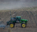 Un tractor equipado con aspersores trabaja sobre un campo arado, mostrando cómo la Aerotermia puede integrarse a la agricultura de precisión.