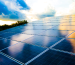 Paneles solares captan los últimos rayos del sol con reflejos en el cielo, ilustrando el avance de Uruguay en el uso de Aerotermia para energías renovables.